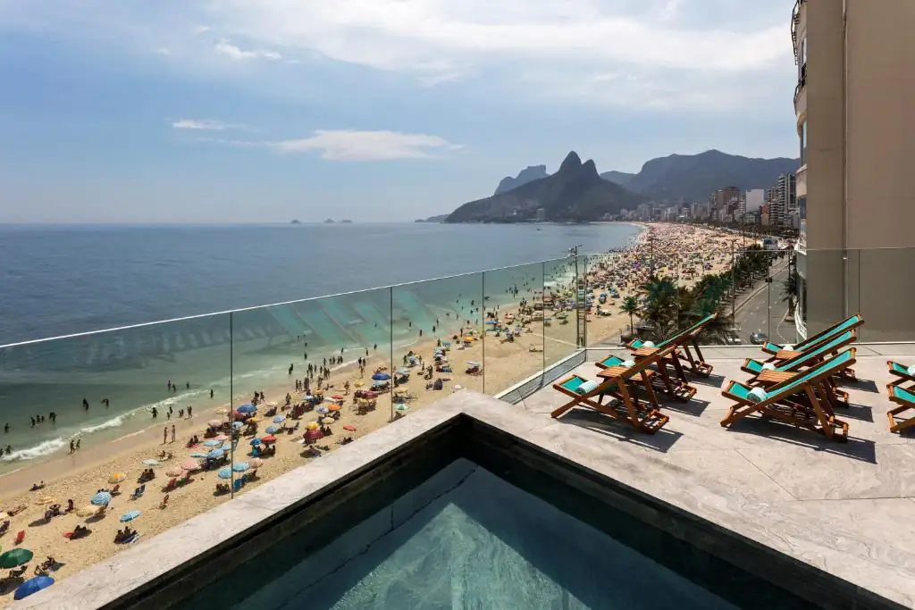 a view of a beach and the ocean from a building at Hotel Arpoador in Rio de Janeiro