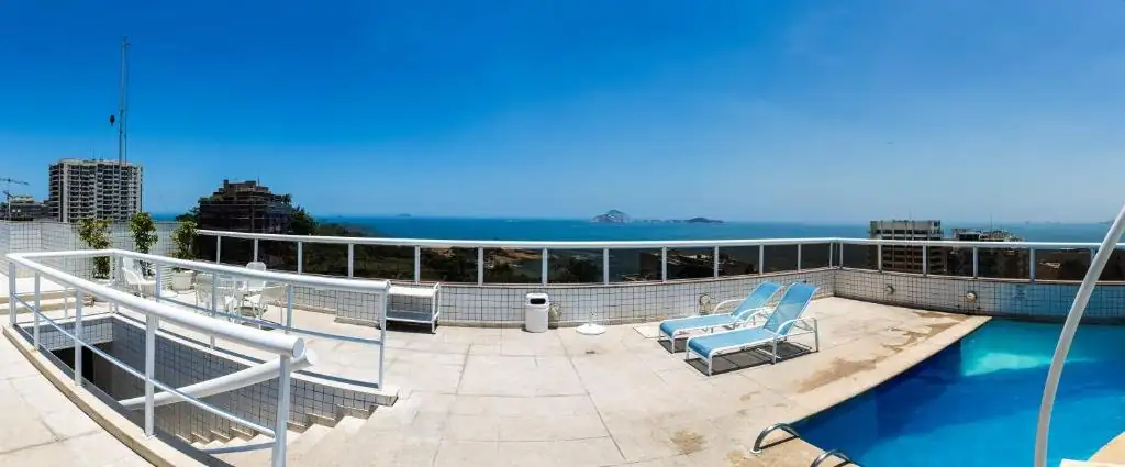 uma varanda com uma cadeira azul em um navio de cruzeiro em Atlantis Copacabana Hotel no Rio de Janeiro