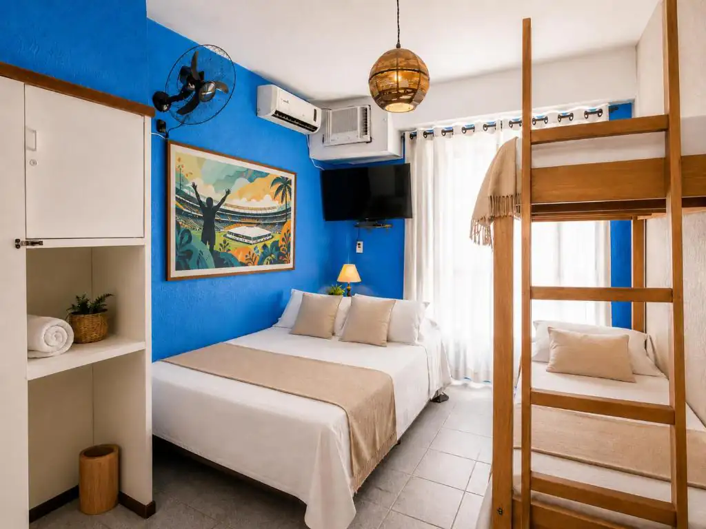 a bedroom with two beds and a blue wall at Bits & Bossa Hostel Rio de Janeiro in Rio de Janeiro