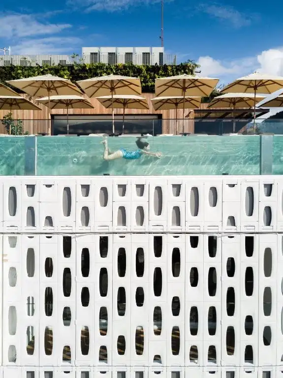 uma pessoa nadando em uma piscina com guarda-sóis em Emiliano Rio no Rio de Janeiro