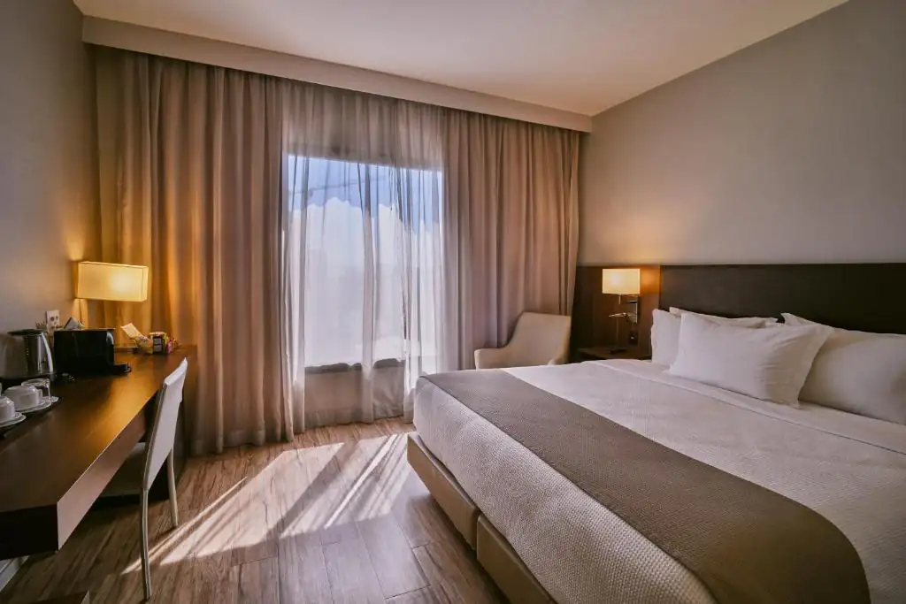 a hotel room with a bed and a desk and a window at Intercity Rio de Janeiro Porto Maravilha in Rio de Janeiro