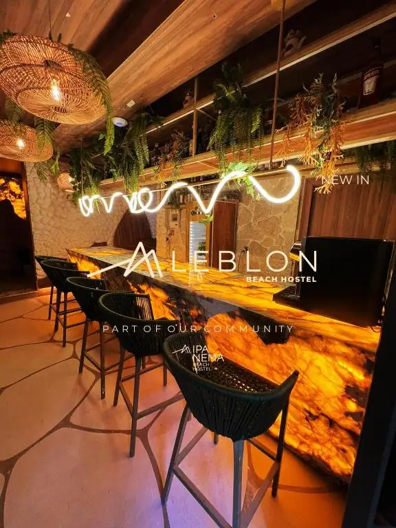 um restaurante com cadeiras e um bar com os dizeres "bem-vindo ao salão". em Leblon Beach Hostel no Rio de Janeiro