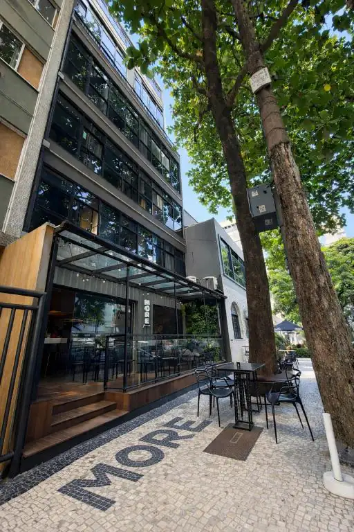 a building with tables and chairs in front of it at More Ipanema Hostel in Rio de Janeiro