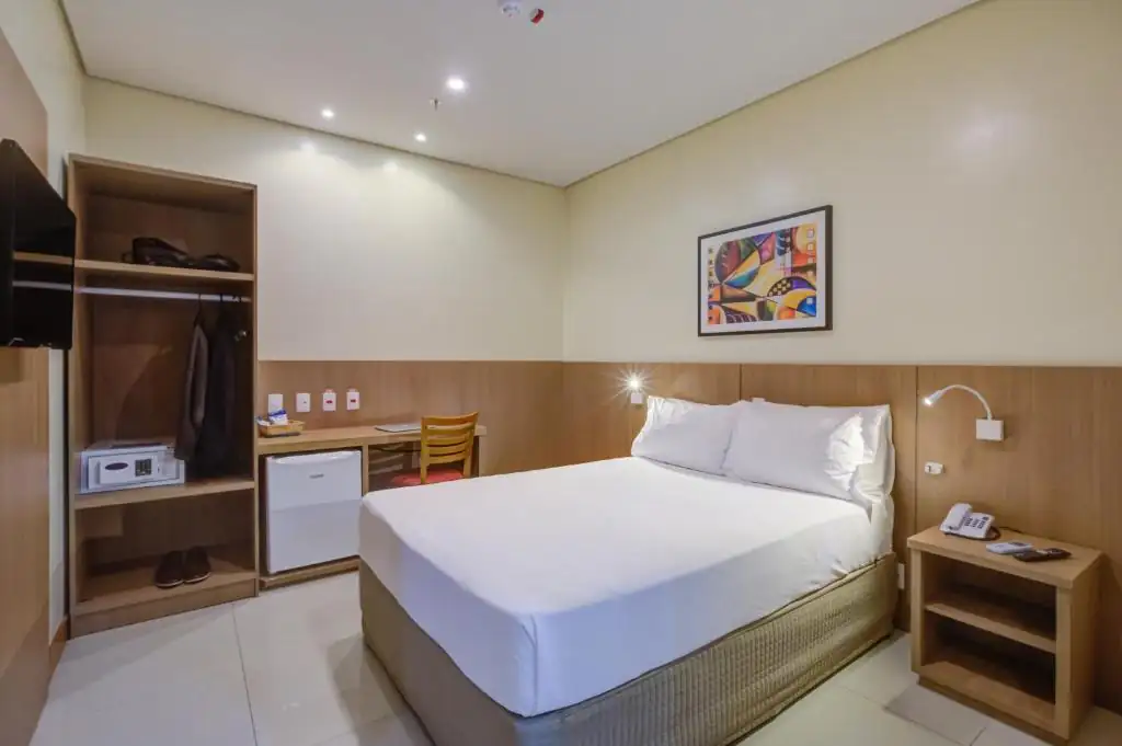 a bedroom with a bed and a desk and a television at Rio Aeroporto Hotel Galeão in Rio de Janeiro