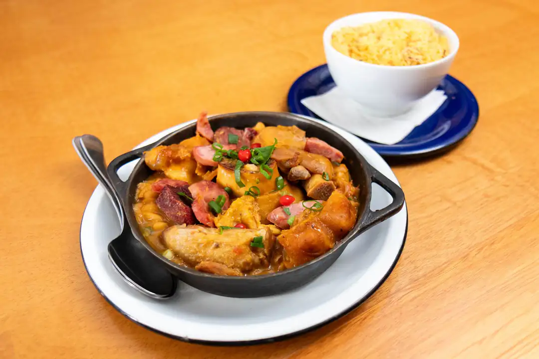 Brazilian feijoada served with rice on a wooden table