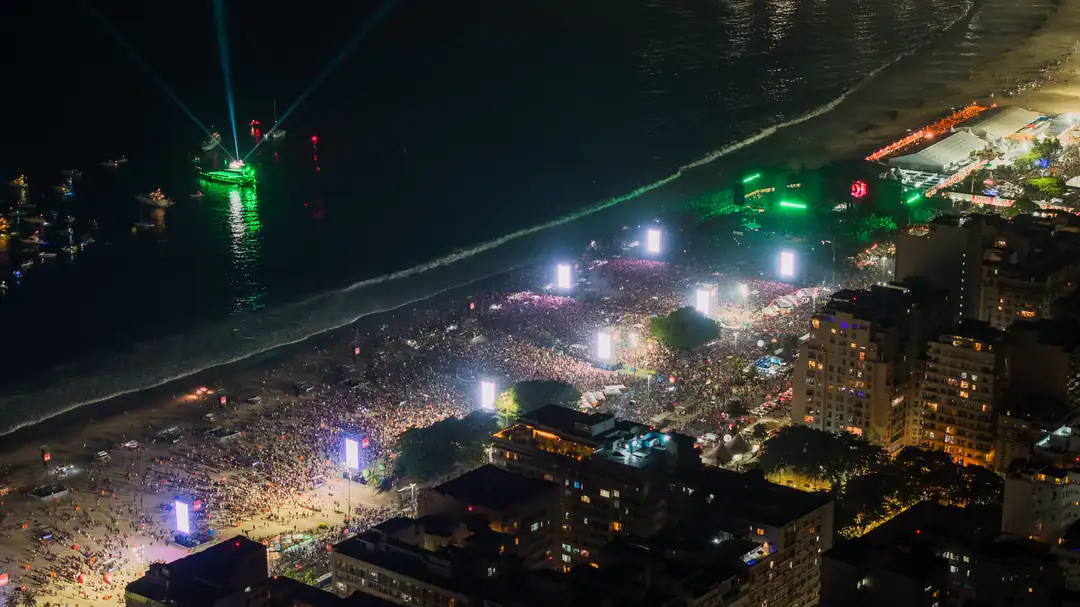 Copacabana Beach filled with people during a nighttime celebration