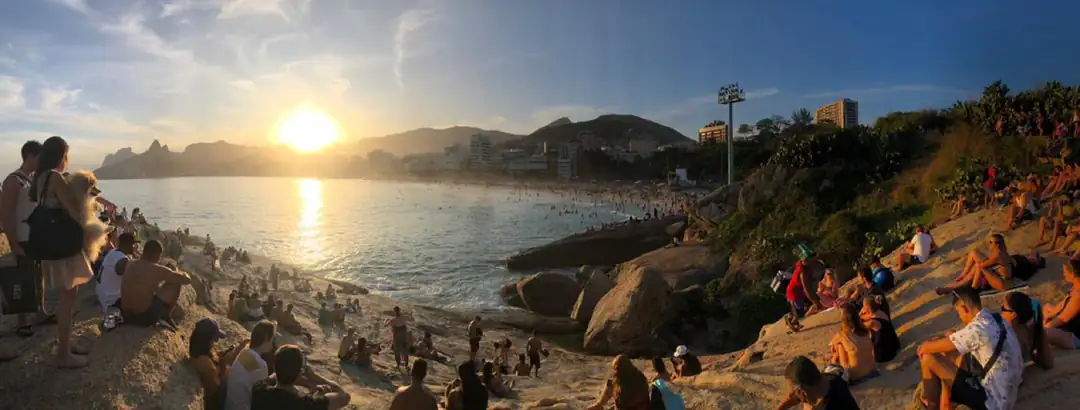 Visitors gathering on Pedra do Arpoador at sunset