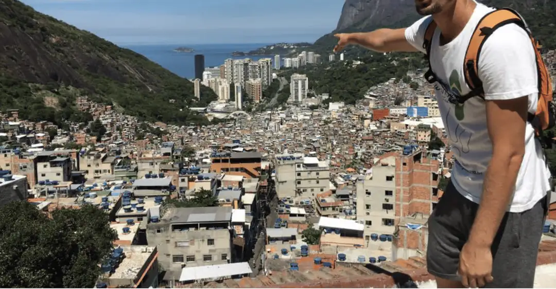 A local guide points across Rocinha from a hillside viewpoint